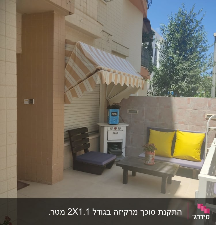 סוכך פסים לבן וכתום מותקן מעל חלון